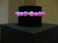 Pulseras de bolas rosa con abalorios de metal una de ellas con colgante